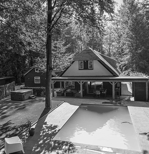 Luxe rietgedekte woning met buitenzwembad en overdekt terras in groene omgeving