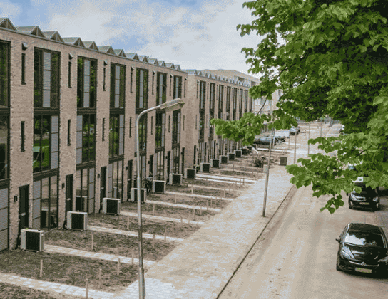 Rij nieuwe starterswoningen aan een groene straat