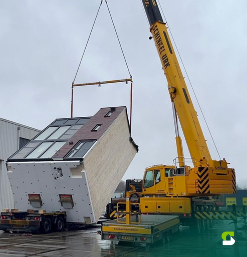 Hijskraan plaatst een prefab Starblock-woning op de bouwlocatie
